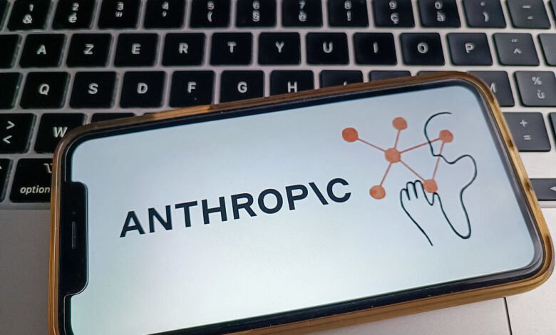Anthropic AI logo displayed on a smartphone screen resting on a laptop keyboard.