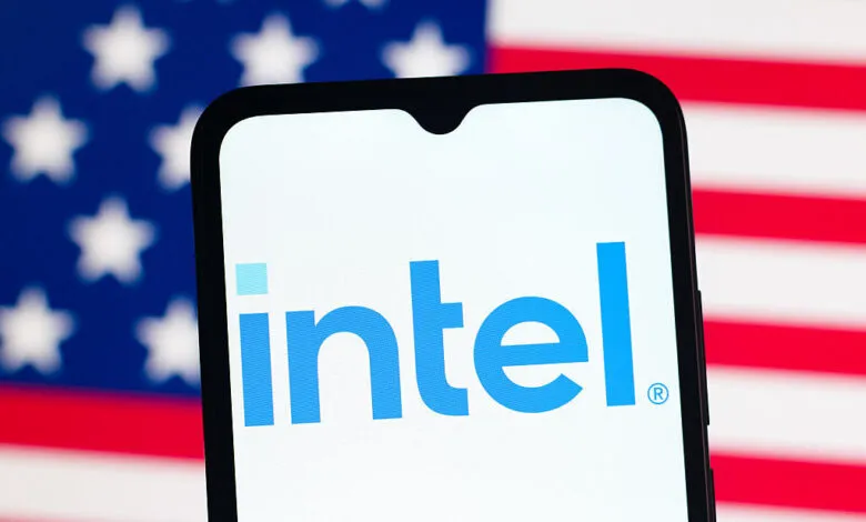 Intel logo displayed on a smartphone screen with a blurred US flag in the background.