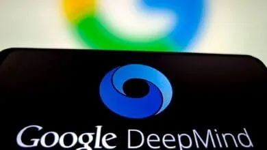 Close-up of a smartphone displaying the Google DeepMind logo, with a blurred Google logo in the background.