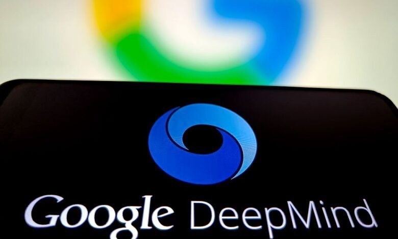 Close-up of a smartphone displaying the Google DeepMind logo, with a blurred Google logo in the background.