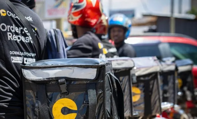 Close-up of food delivery drivers in Africa, wearing black shirts with the 'Order & Repeat' logo and carrying insulated delivery bags.