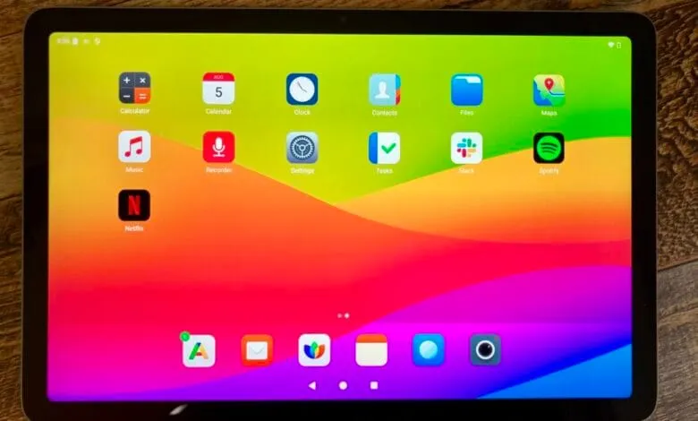 Tablet displaying a home screen with various app icons, including Netflix, Spotify, and Slack, against a vibrant, colorful background.