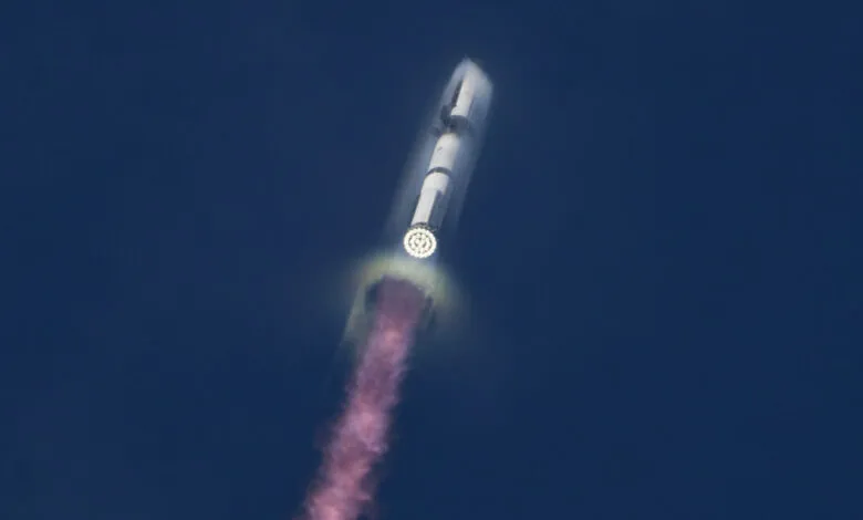 Rocket launching into space, leaving a pink trail against a dark blue sky.