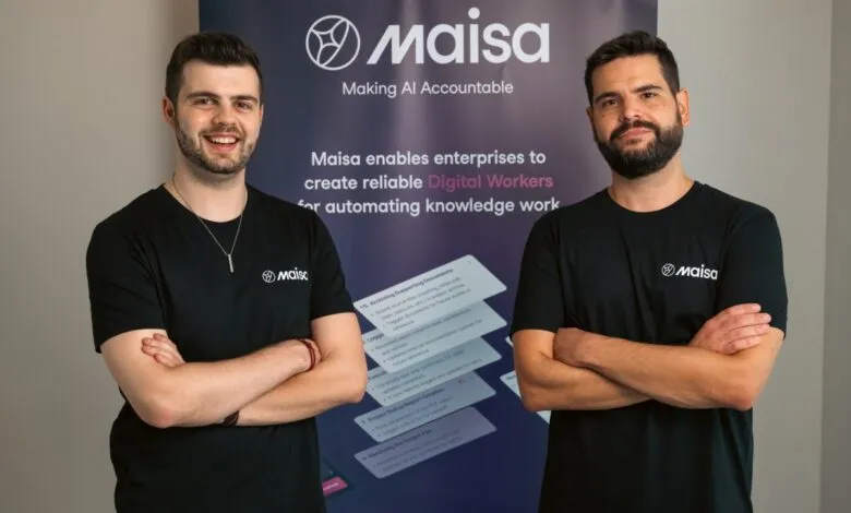Maisa founders, David Villalon and Manuel Romera, stand smiling with arms crossed, in front of a company banner.