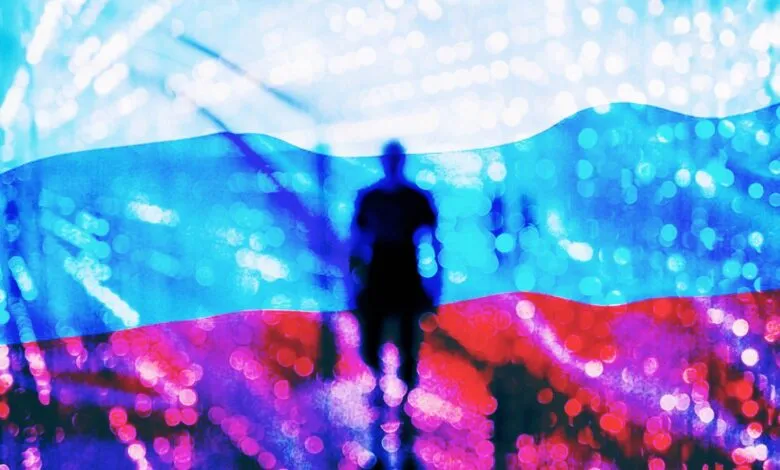 Silhouette of a person in front of a blurred Russian flag with bokeh lights.
