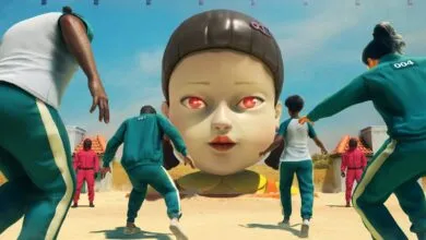 Squid Game contestants run from a giant doll with red glowing eyes.