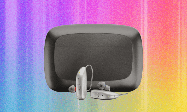 Three hearing aids and a gray charging case against a colorful background.