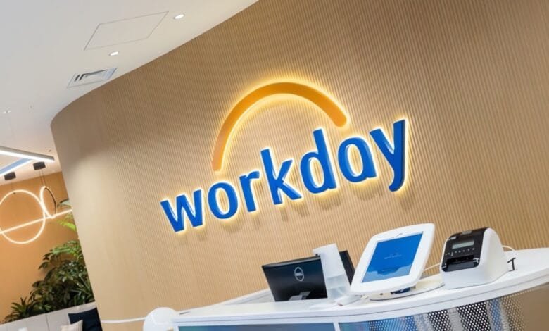 Workday logo displayed prominently on a light wood wall in a modern office reception area.