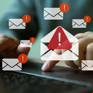 Person's hands on laptop with multiple email alert notifications.