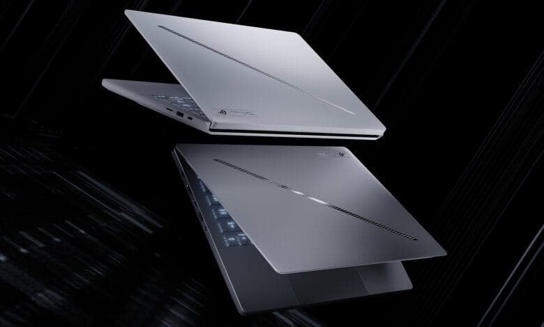 Two sleek silver ASUS ROG Zephyrus laptops hover against a dark background, showcasing their design and features.