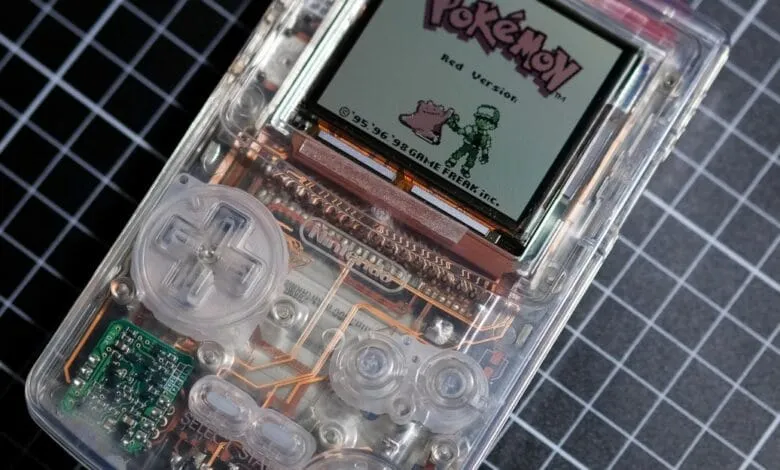 Close-up of a transparent Game Boy showing its internal components, displaying the Pokémon Red Version title screen.