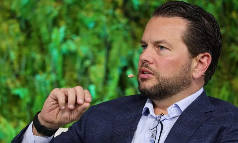 Bill Ready, Pinterest CEO, speaks at a conference, wearing a blue blazer and light blue shirt.