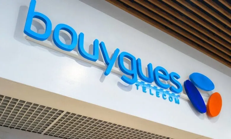 Bouygues Telecom logo on a white wall, with blue lettering and colorful circular accents.