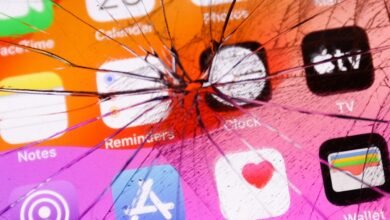 Close-up of a shattered iPhone screen displaying various apps like Calendar, Clock, and Health.