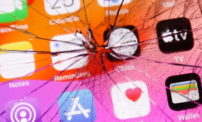 Close-up of a shattered iPhone screen displaying various apps like Calendar, Clock, and Health.