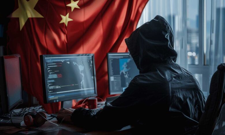 Hooded figure sits at computer, Chinese flag in background, suggesting cybercrime or hacking.