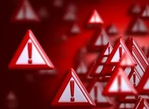 Many red triangular warning signs with exclamation points float in a red background.