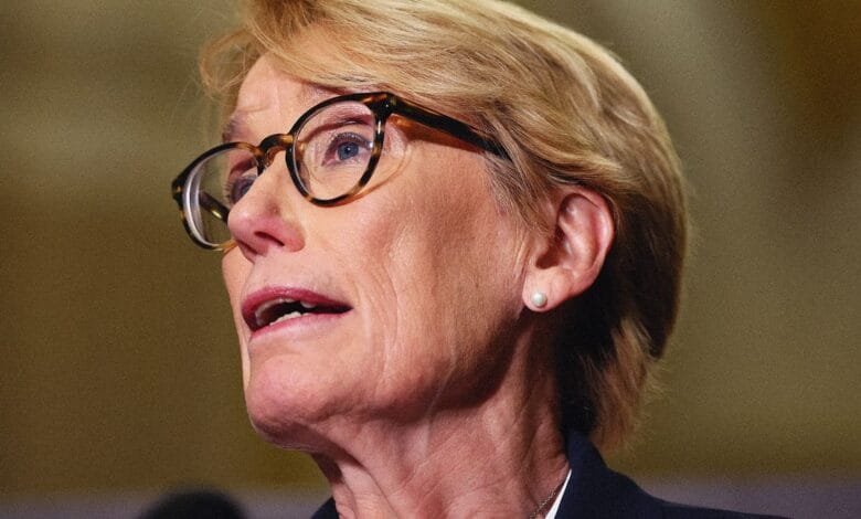 Close-up of Senator Maggie Hassan speaking, wearing glasses and a dark jacket.