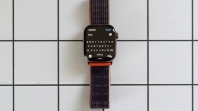 Apple Watch displaying a full keyboard on its screen, with a dark-colored woven band.