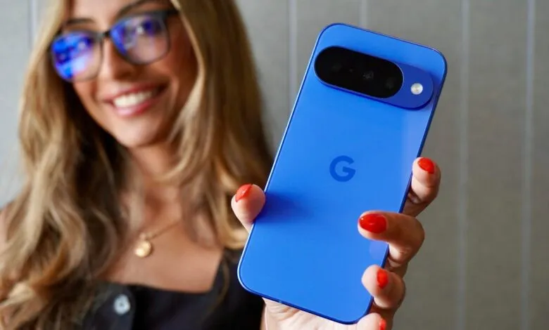 Woman holding a vibrant blue Google Pixel phone, smiling.