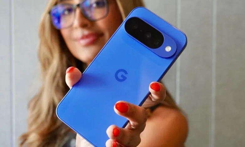 Woman holding up a vibrant blue Google Pixel phone, showcasing its camera and Google logo.