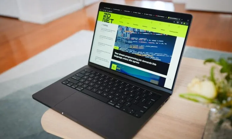 Laptop displaying ZDNet article about programming job demand, showcasing code snippets on screen.