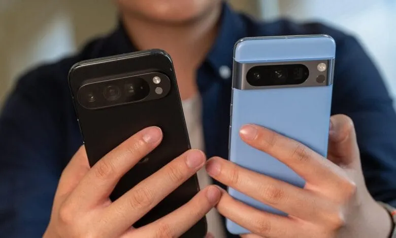 Close-up of two smartphones, one black and one light blue, held in a person's hands.