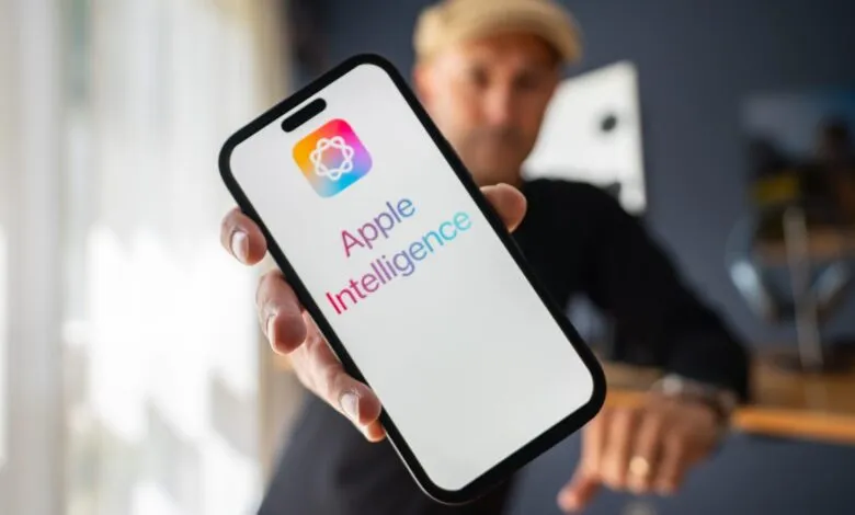 Close-up of a person holding a smartphone displaying the Apple Intelligence app logo and name.