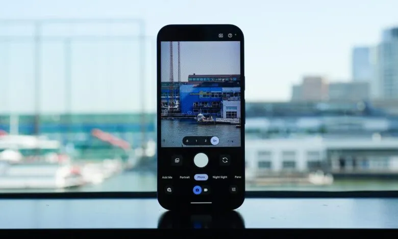 Smartphone displaying a camera app interface, capturing a waterfront cityscape.