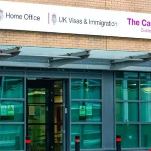 UK Visas & Immigration office entrance. Modern building with glass doors and signage.