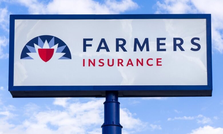 Farmers Insurance sign against a blue sky. The logo features a red shield within a stylized flower.