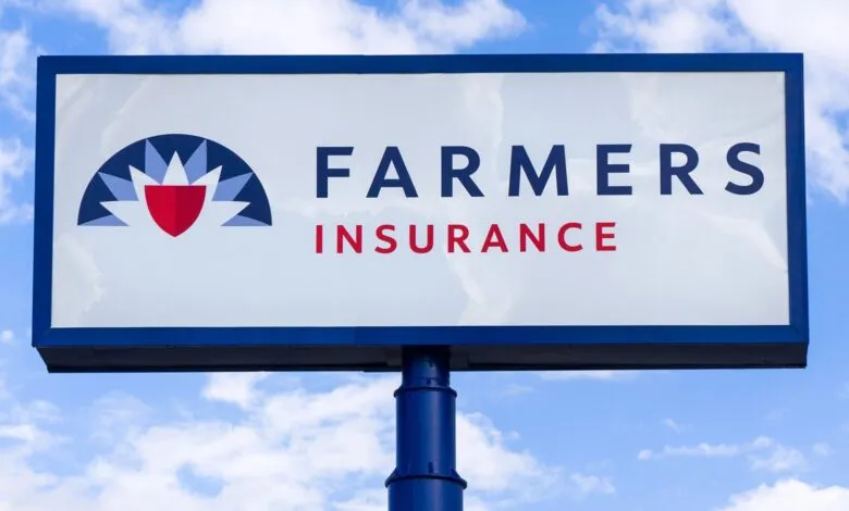 Farmers Insurance sign against a blue sky. The logo features a red shield within a stylized flower.