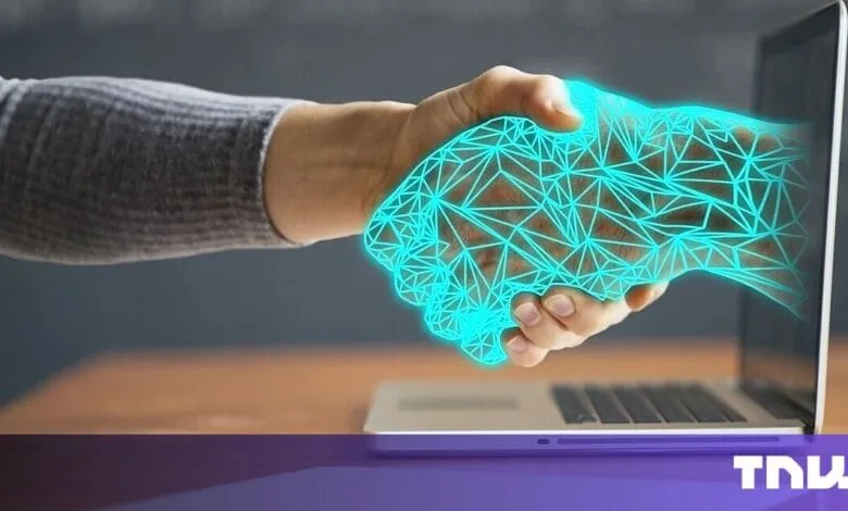 A human hand shakes a digital hand emerging from a laptop screen, symbolizing the connection between humans and technology.