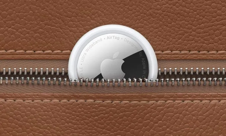 Apple AirTag in a brown leather pouch, partially visible in a zippered pocket.