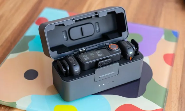 Wireless microphone system in charging case, showing battery levels and controls.