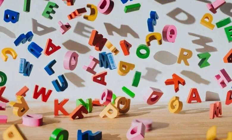 Colorful wooden letters falling onto a table, creating a vibrant and playful scene.