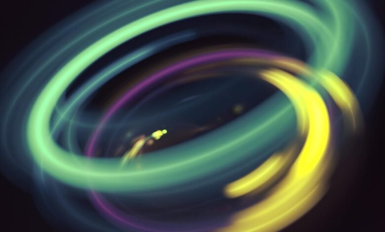 Abstract swirling light patterns in teal, purple, and yellow, creating a dynamic, energetic visual.