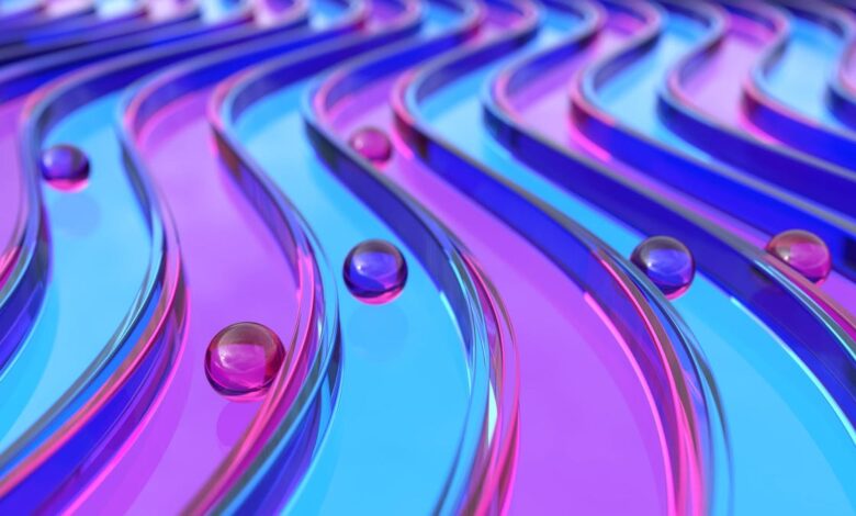 Abstract image of pink and blue glass curves with spheres rolling along them.
