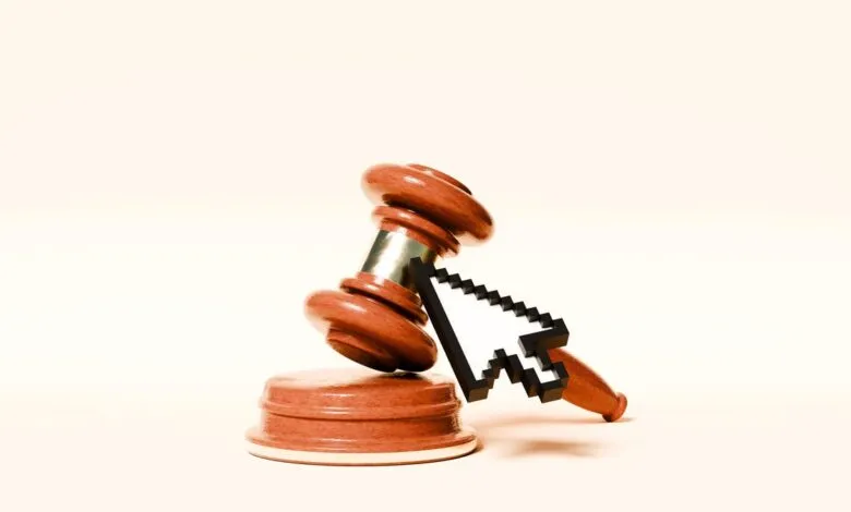 Wooden gavel and pixelated cursor, symbolizing online justice or cyber law.