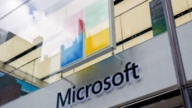Microsoft store signage with the company logo and Windows colors displayed on a modern building.