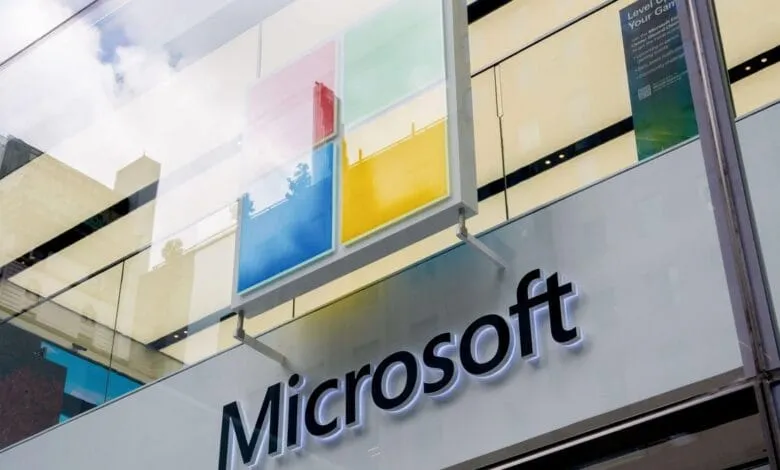 Microsoft store signage with the company logo and Windows colors displayed on a modern building.