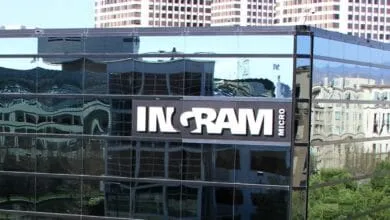 Ingram Micro headquarters building reflected in its glass facade, showcasing the company logo.