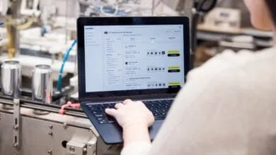 Person using Keychain software on laptop to manage chocolate manufacturers. The screen shows product listings and filters.