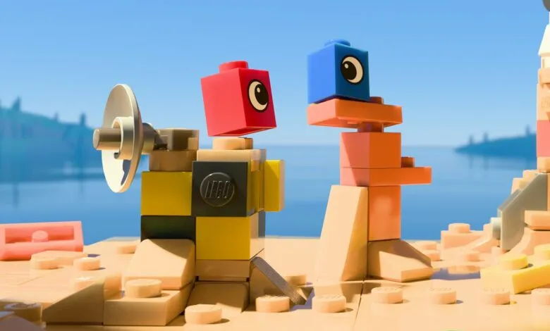 Two LEGO figures, one with a satellite dish, converse on a sandy beach against a bright blue sky.