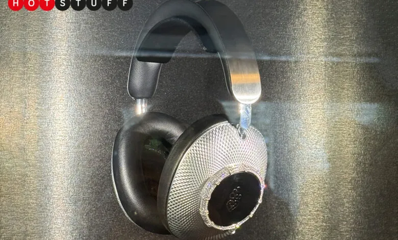 Luxury Loewe headphones encrusted with diamonds, hanging in a display case.