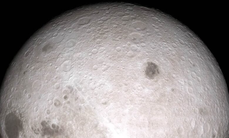Close-up of the moon's far side, showing its cratered surface in shades of gray against a black background.