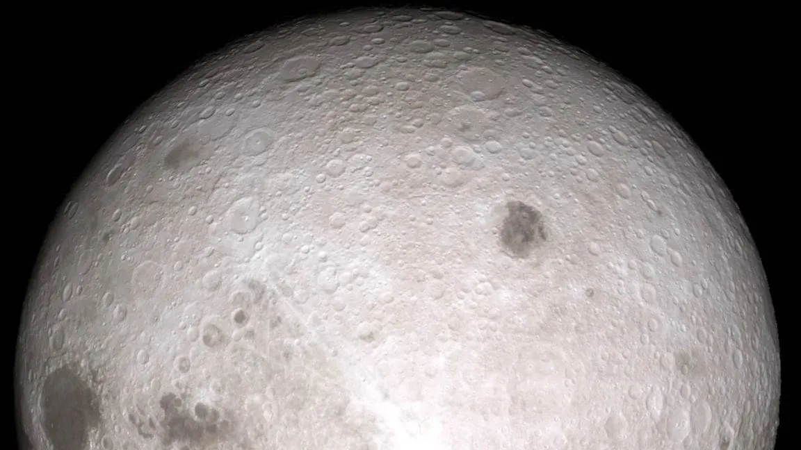 Close-up of the moon's far side, showing its cratered surface in shades of gray against a black background.