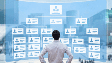 A businessman views a digital organizational chart projected onto a large screen, showing a hierarchical structure of employees.