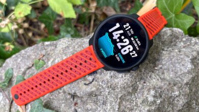 Orange Suunto sports watch with a detailed display resting on a textured rock.