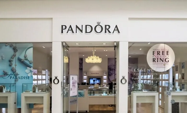 Pandora jewelry store storefront with display showcasing rings and charms. A sign advertises a free ring with purchase.